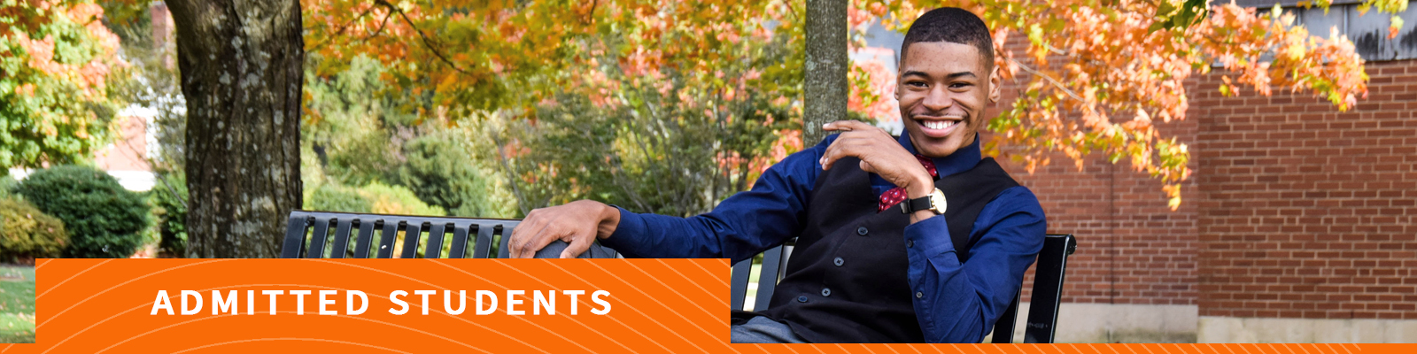 Man smiling on bench on campus