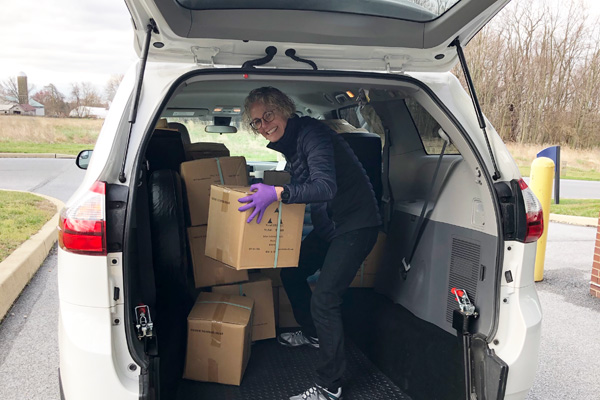 Dr. Anna Hull loads personal protective equipment