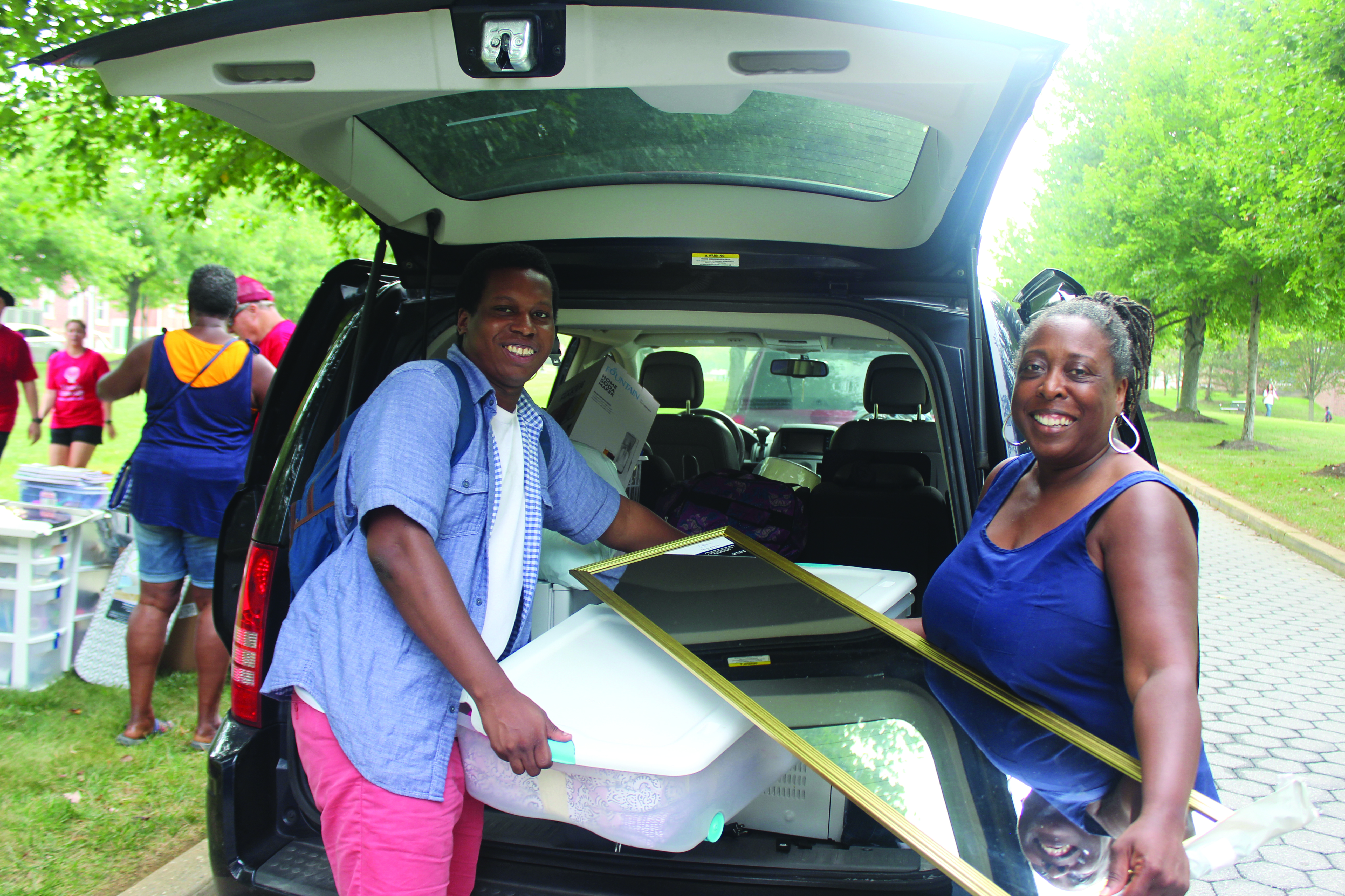 student and parent unpacking their car