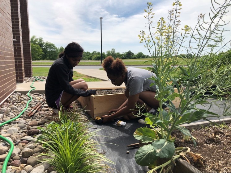 two students planting