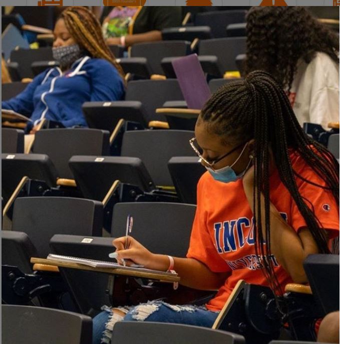 student seated at desk writing